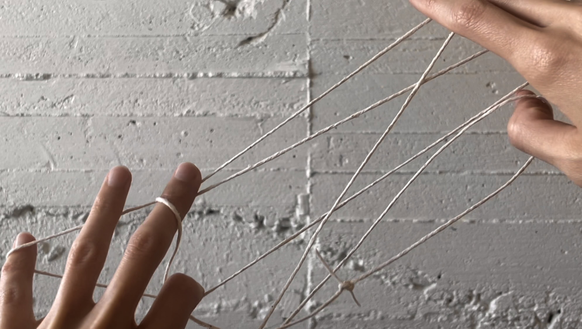 Two hands, connected by thread